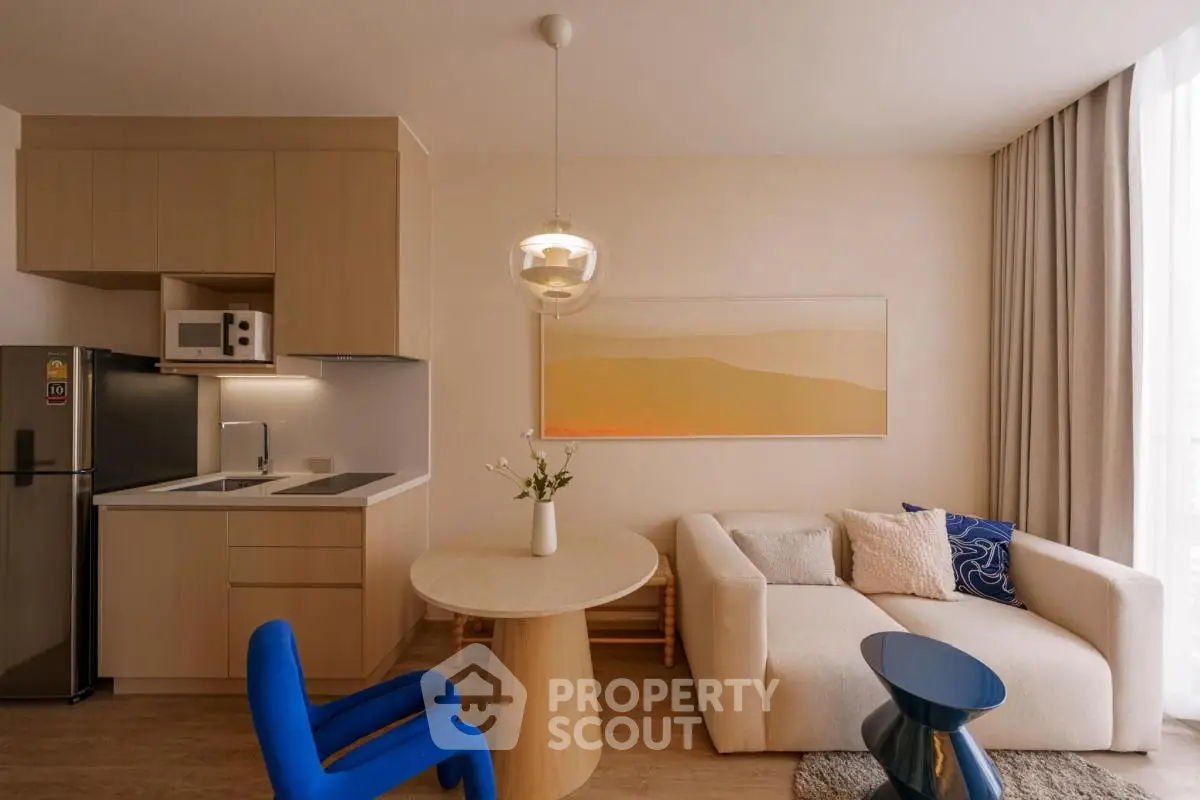 Modern open-layout living room with stylish kitchen and cozy seating area.