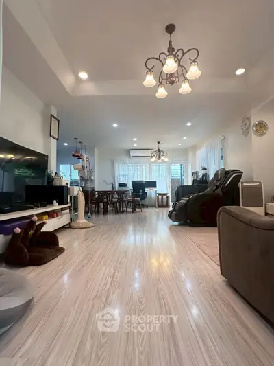 Spacious living room with elegant lighting and modern decor, perfect for family gatherings.