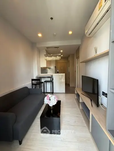 Modern living room with sleek furniture and open kitchen layout in a stylish apartment.