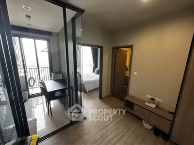 Modern apartment interior with glass partition, cozy bedroom, and stylish dining area.