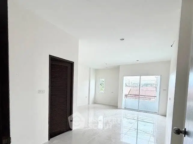 Spacious bright room with large windows and balcony access, perfect for modern living.