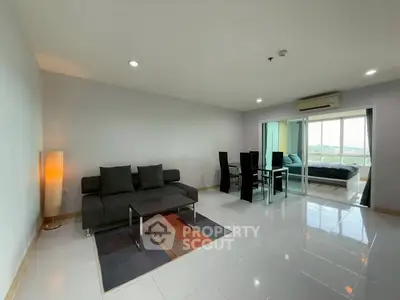 Spacious modern living room with sleek furniture and large windows offering a stunning view.