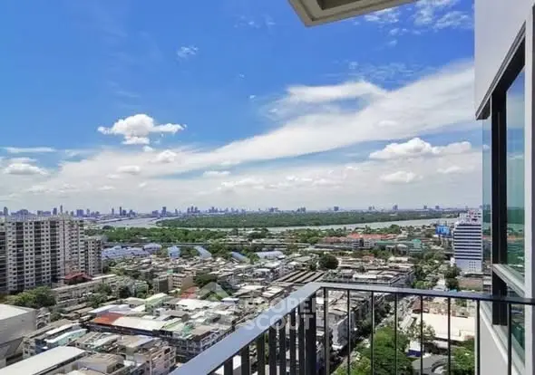 Stunning cityscape view from a high-rise balcony with clear blue skies.