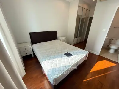 Spacious bedroom with hardwood floors and natural light