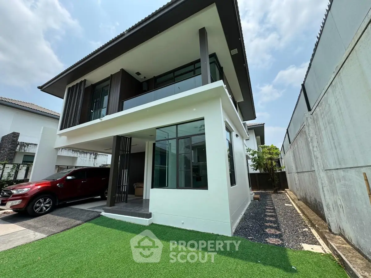 Modern two-story house with sleek design and spacious driveway, featuring a well-maintained lawn and contemporary architecture.