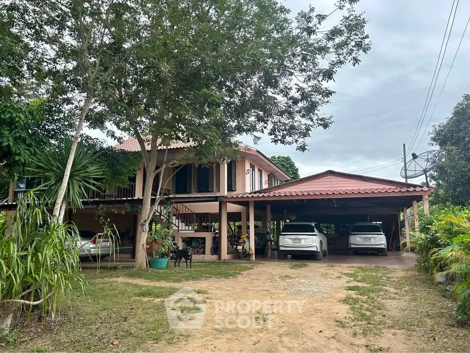 Charming two-story home with spacious carport and lush greenery, perfect for family living.