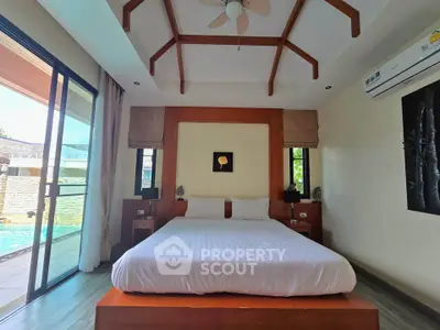 Luxurious bedroom with pool view and modern wooden accents in a serene setting.