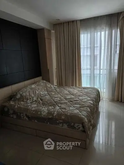 Cozy bedroom with large window and elegant curtains in modern apartment.