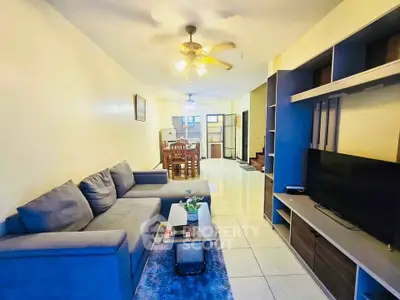 Spacious living room with modern furniture and ceiling fan, perfect for relaxation and entertainment.