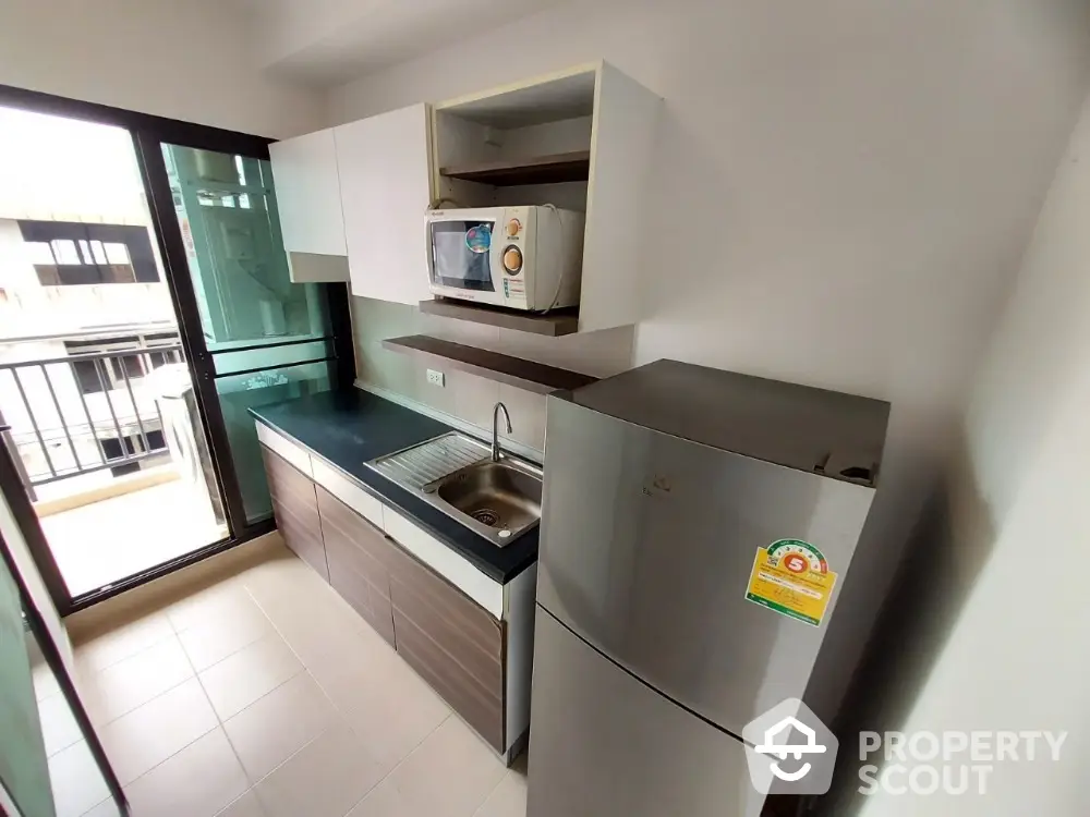 Modern kitchen with sleek cabinetry and balcony access