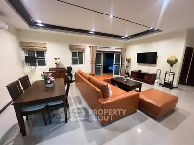 Spacious modern living room with elegant decor and leather sofa, perfect for family gatherings.