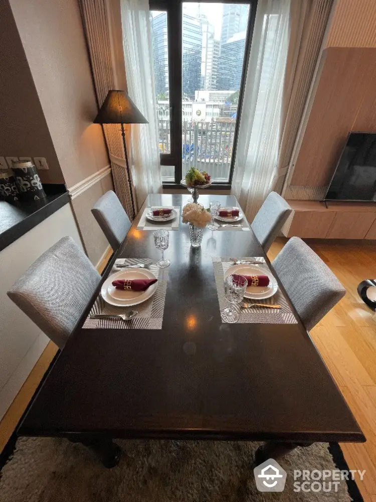 Elegant dining area with city view, featuring a stylish table setting and modern decor.