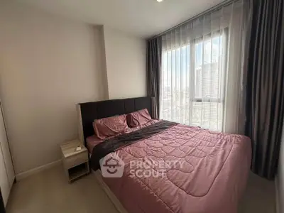 Cozy bedroom with large window and city view, featuring a comfortable bed and modern decor.