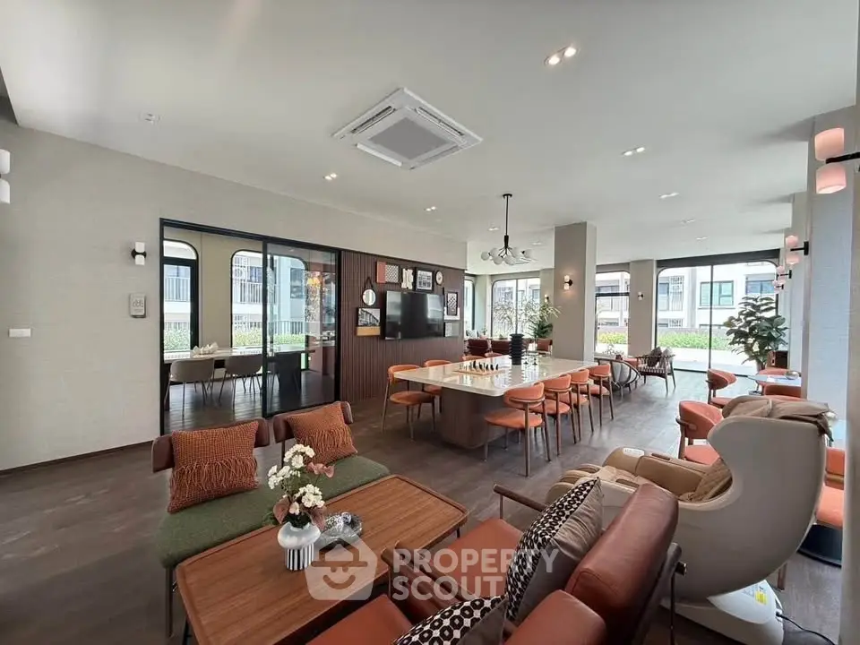 Spacious modern living room with stylish furniture and large windows offering natural light.