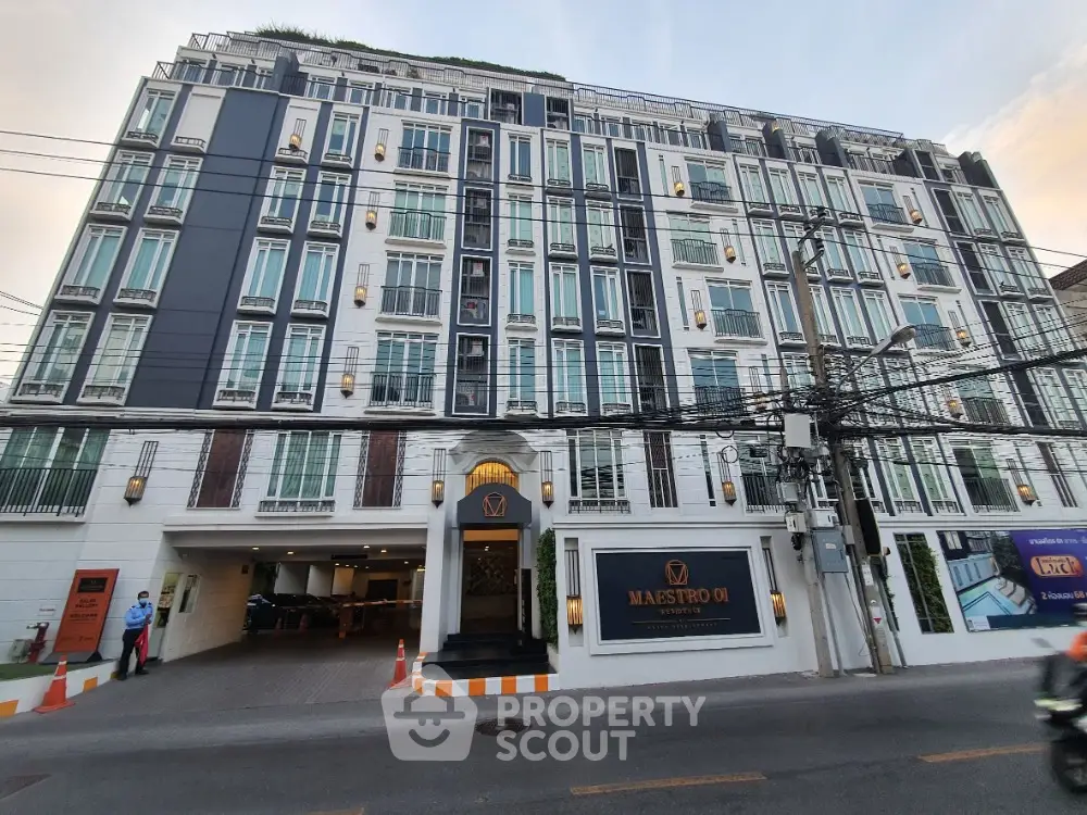 Elegant modern building exterior with stylish facade and ample parking space.