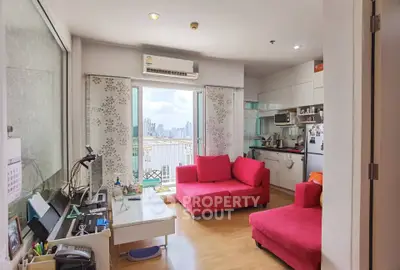 Modern living room with vibrant red sofas and city view balcony