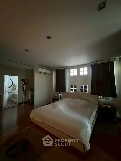 Cozy bedroom with large bed and natural light through windows