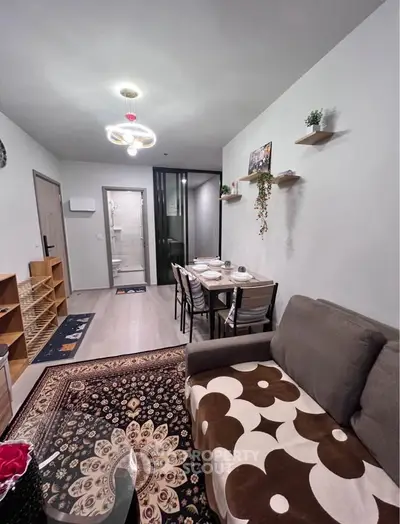 Modern living room with stylish decor and dining area, featuring cozy seating and elegant lighting.