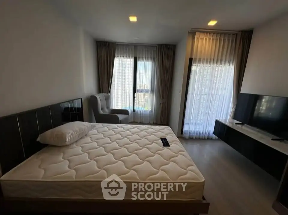 Spacious bedroom with large windows and modern furnishings, perfect for relaxation and comfort.