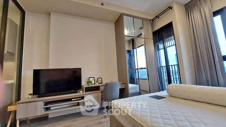 Modern bedroom with stylish decor and large windows offering a stunning view, perfect for urban living.