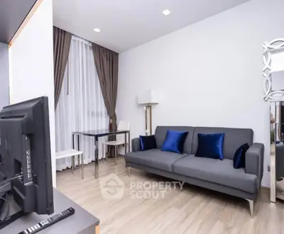 Modern living room with sleek gray sofa and elegant decor in a stylish apartment.