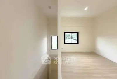 Spacious modern room with large windows and wooden flooring, perfect for versatile living space.