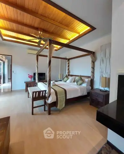 Luxurious bedroom with elegant four-poster bed and wooden ceiling accents