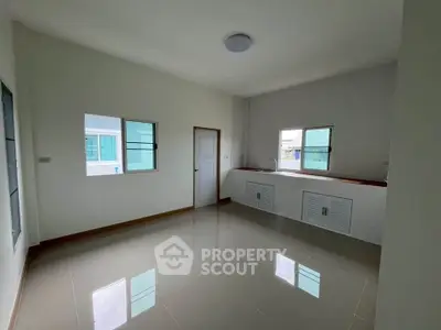 Spacious empty room with tiled floor and natural light from windows.