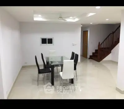 Modern dining area with glass table and elegant chairs in a spacious interior
