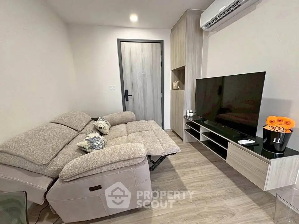 Modern living room with cozy sofa and sleek TV setup in stylish apartment.