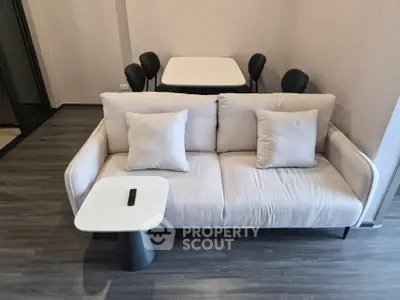 Modern living room with stylish sofa and dining table in open layout apartment.