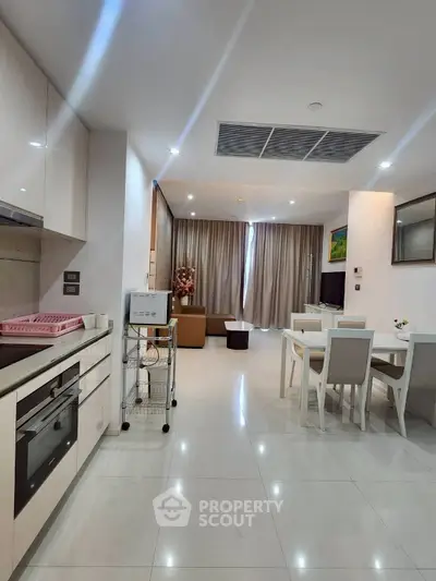 Spacious modern living room with open kitchen and elegant dining area, perfect for entertaining.