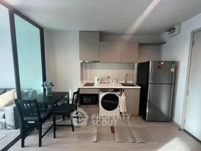 Modern compact kitchen with dining area and appliances in cozy apartment