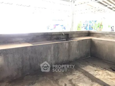 Spacious outdoor kitchen with concrete countertops and sink, perfect for alfresco dining and entertaining.
