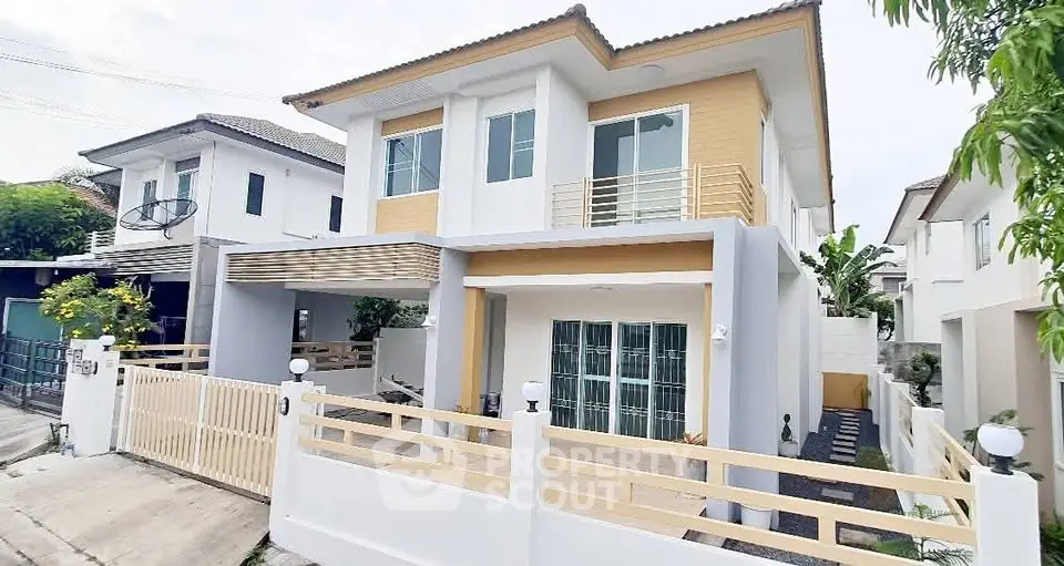 Modern two-story house with stylish facade and gated entrance in a suburban neighborhood.