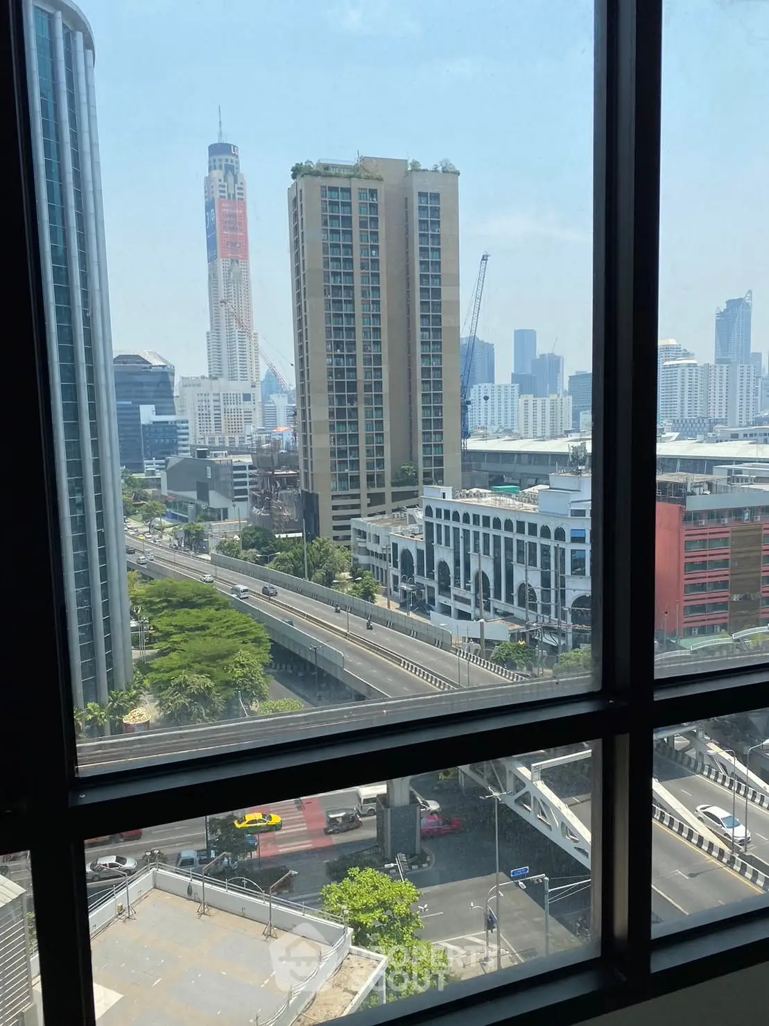 Stunning cityscape view from high-rise apartment window showcasing urban skyline.