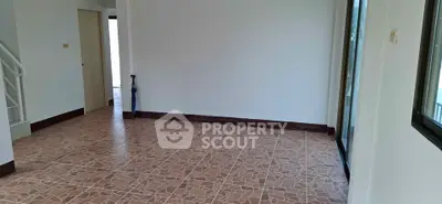 Spacious empty room with tiled flooring and large windows, perfect for customization.