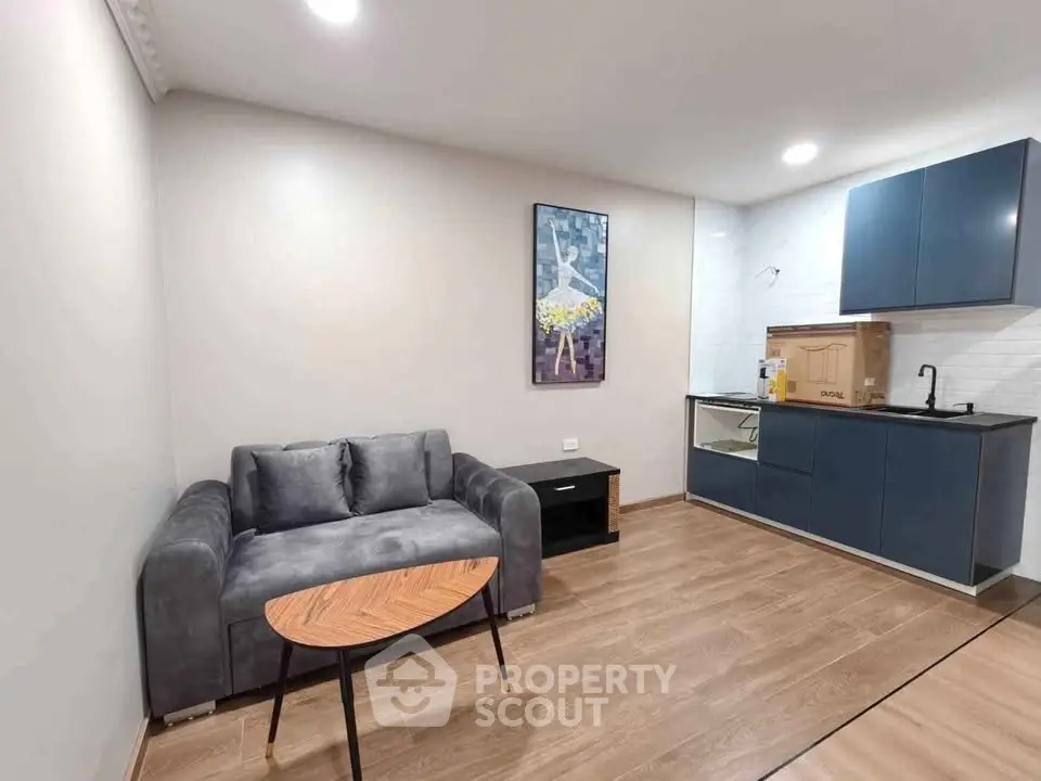 Modern living room with sleek kitchen, stylish sofa, and elegant decor in a contemporary apartment.