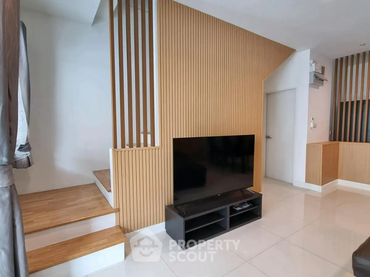 Modern living room with sleek TV setup and stylish wooden accents