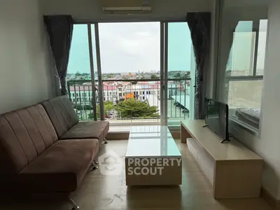 Modern living room with large windows and city view, featuring sleek furniture and natural light.