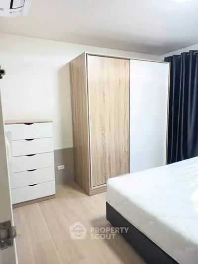 Modern bedroom with sleek wardrobe and natural light, perfect for a cozy living space.