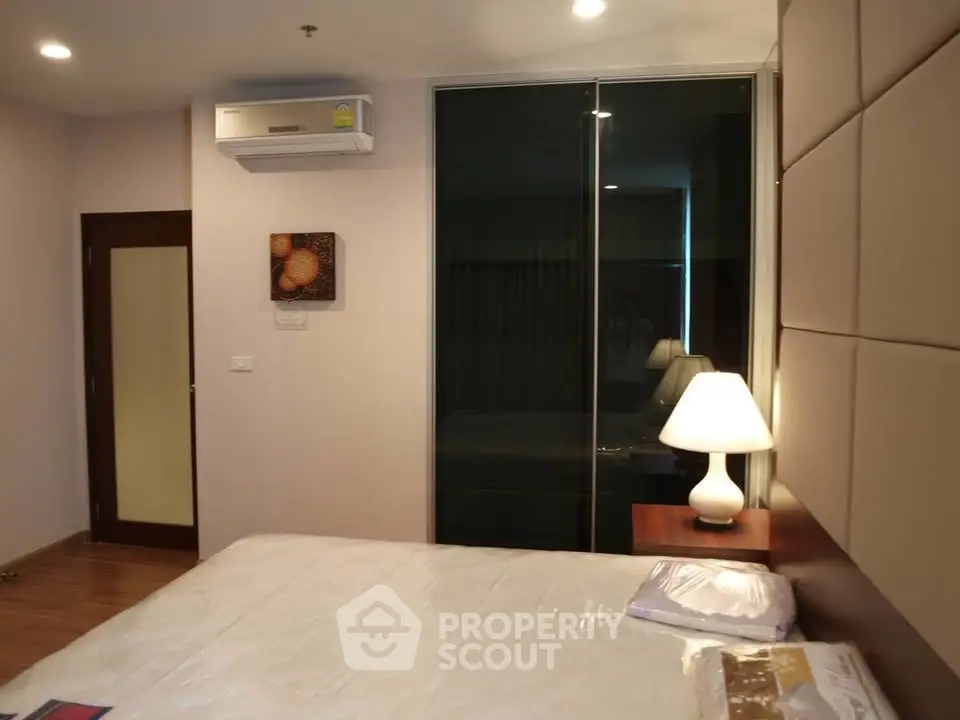 Modern bedroom with stylish decor and ambient lighting, featuring a comfortable bed and sleek air conditioning unit.