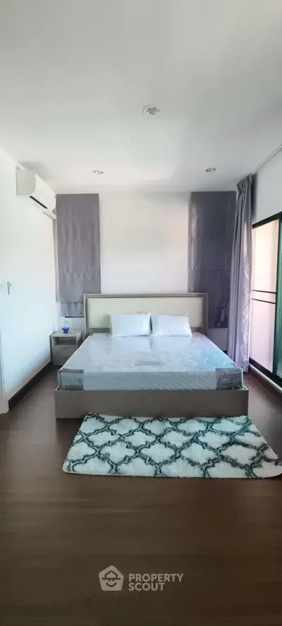 Spacious bedroom with modern decor and large window for natural light