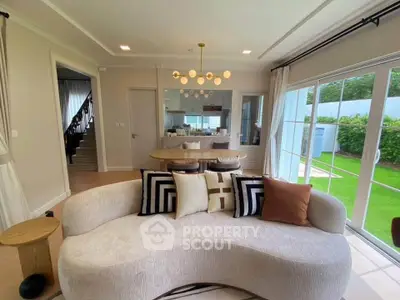 Elegant living room with modern curved sofa and garden view, perfect for stylish entertaining.