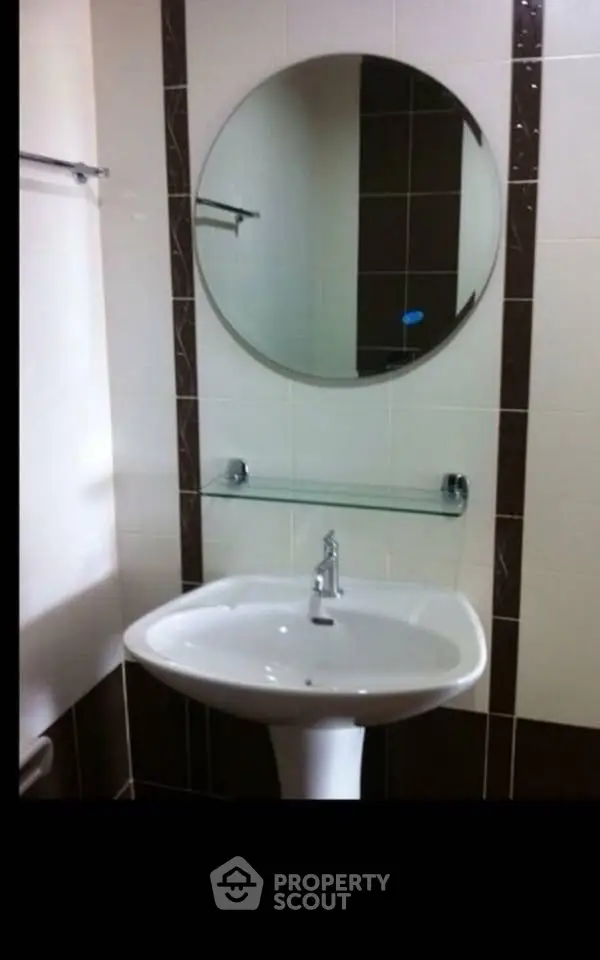 Modern bathroom with sleek pedestal sink and round mirror
