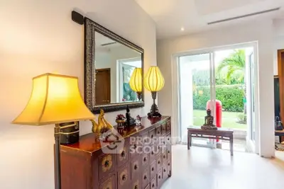 Elegant interior with stylish decor and garden view, featuring a large mirror and unique lighting.