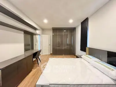 Modern bedroom with sleek furniture and ample storage space