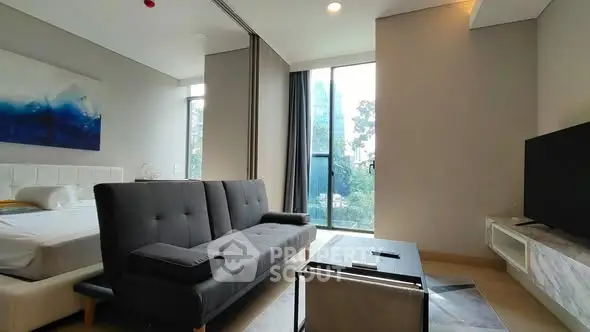 Modern living room with sleek furniture and large windows offering natural light.