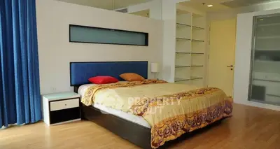 Spacious modern bedroom with stylish decor and ample natural light