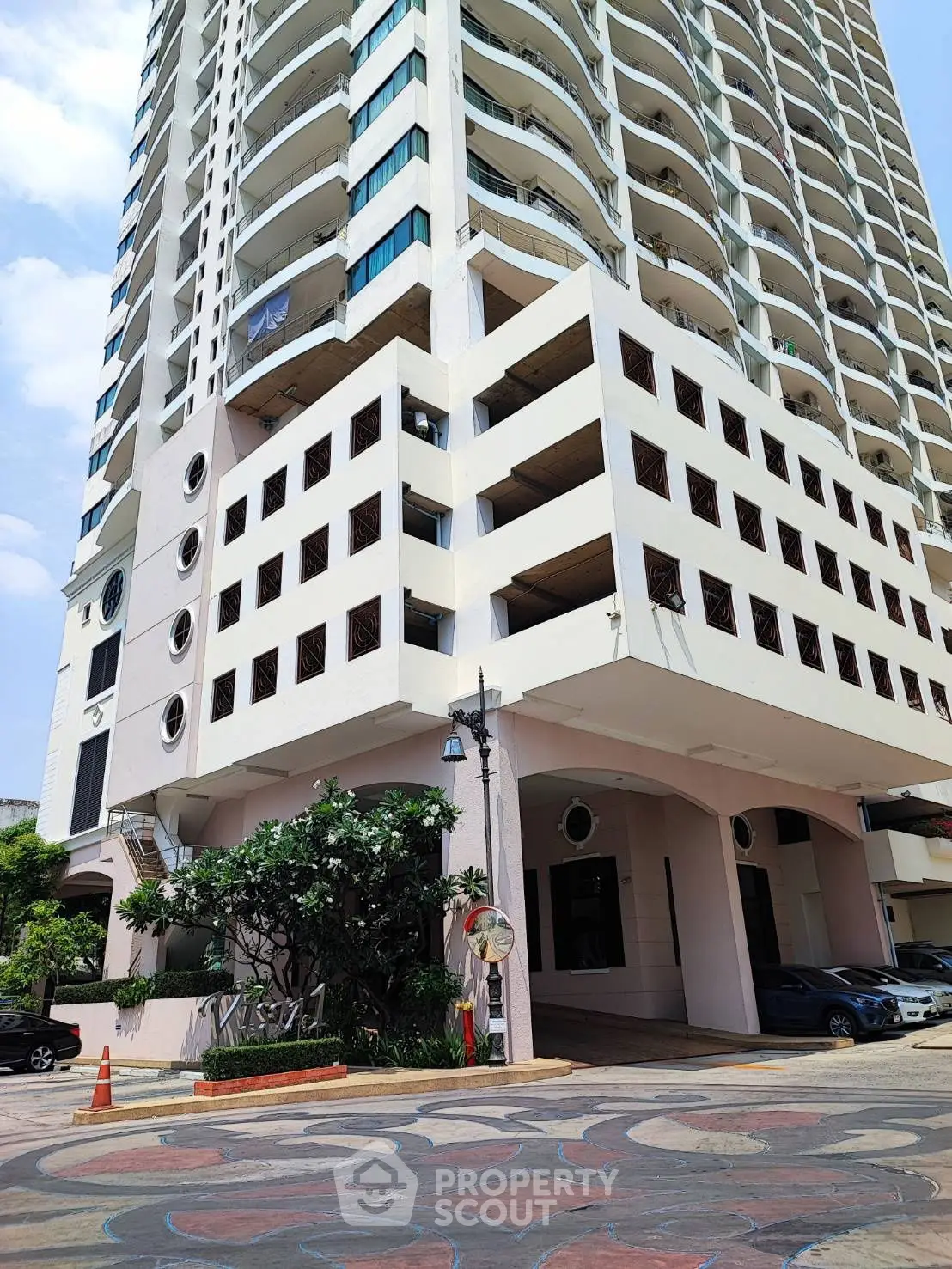 Modern high-rise building with unique architectural design and spacious balconies.